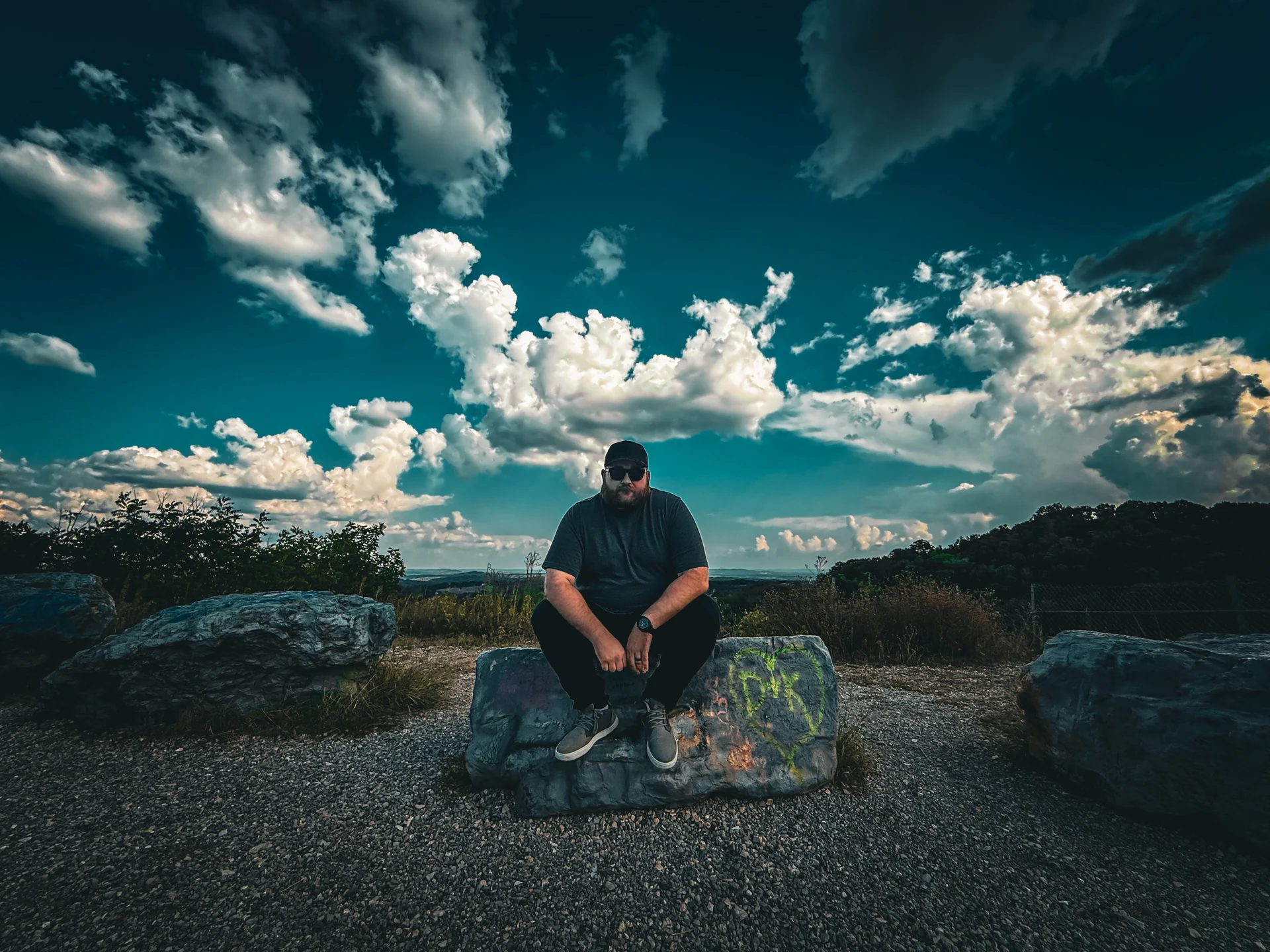 Justice seated beneath a wide cloudy sky